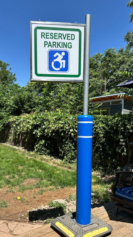 Reserved parking sign for disabled individuals on a metal pole with a blue background.